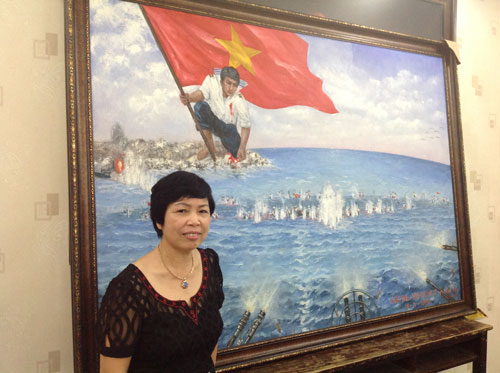 Chị Nguyễn Thị Kim Dung bên bức tranh “Gạc Ma - Vòng tròn bất tử”. (Ảnh do ban tổ chức cung cấp)
